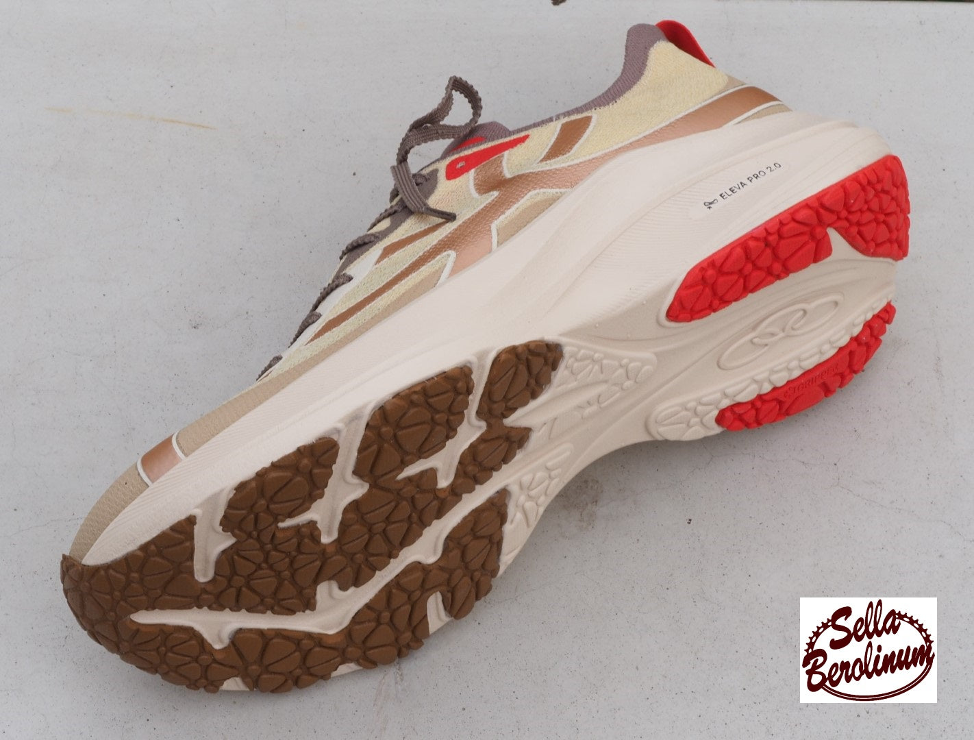 Olympikus Corre 4 Laufschuh in Beige und Sand mit roten Akzenten und Eleva Pro 2.0 Zwischensohle, Sohlenansicht.